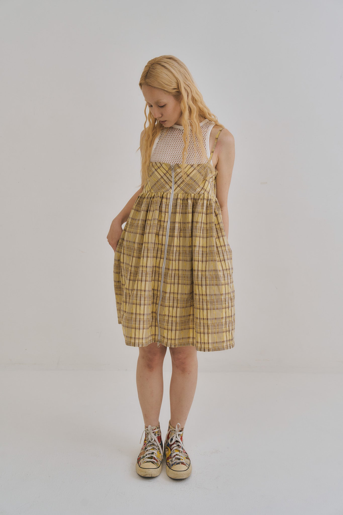 模特兒穿著罌粟黃格紋雙拉鍊口袋洋裝，展現前胸拉鍊細節與純棉面料的蓬鬆垂墜感。