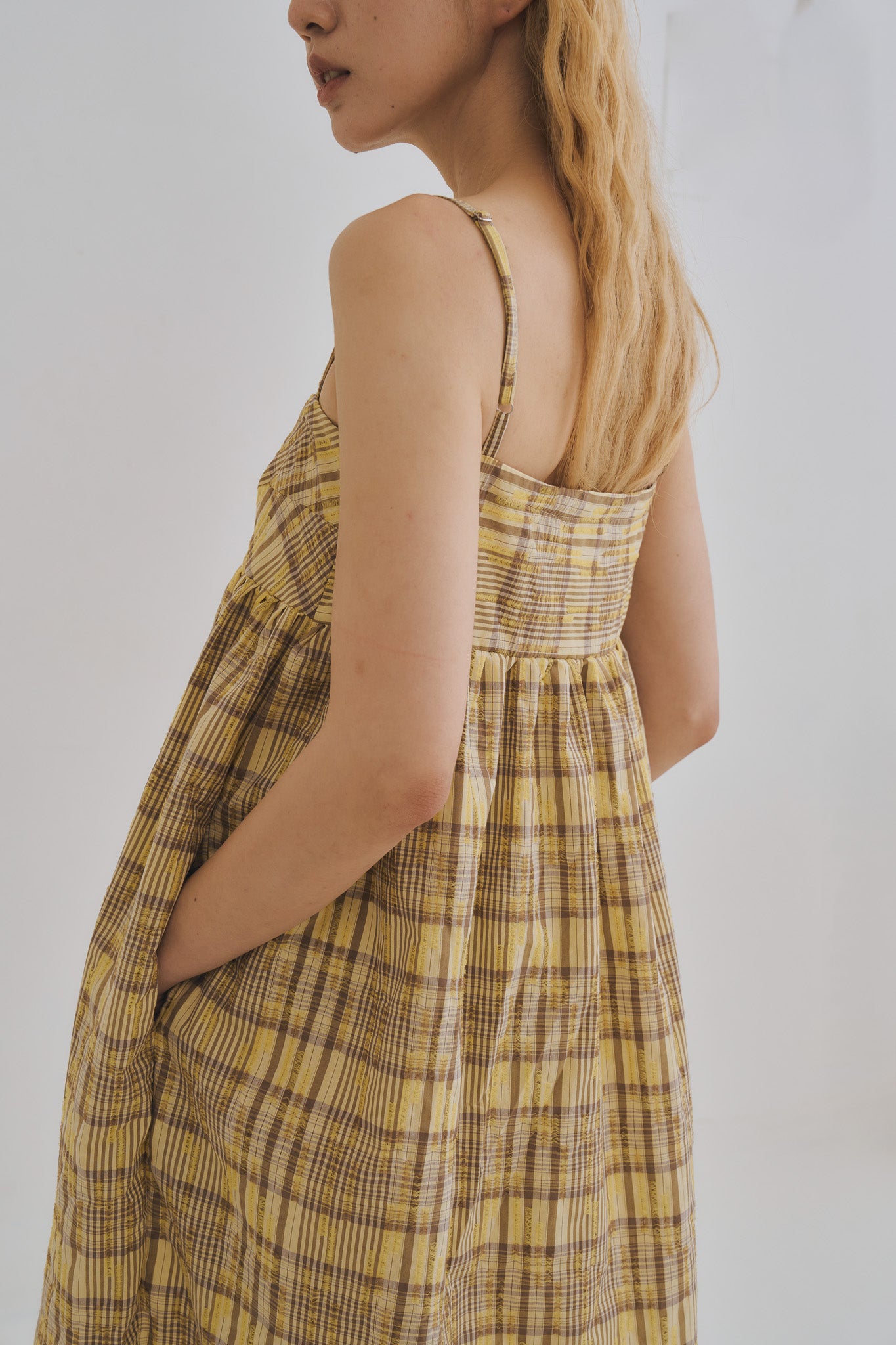 模特兒穿著罌粟黃格紋雙拉鍊口袋洋裝，展現前胸拉鍊細節與純棉面料的蓬鬆垂墜感。