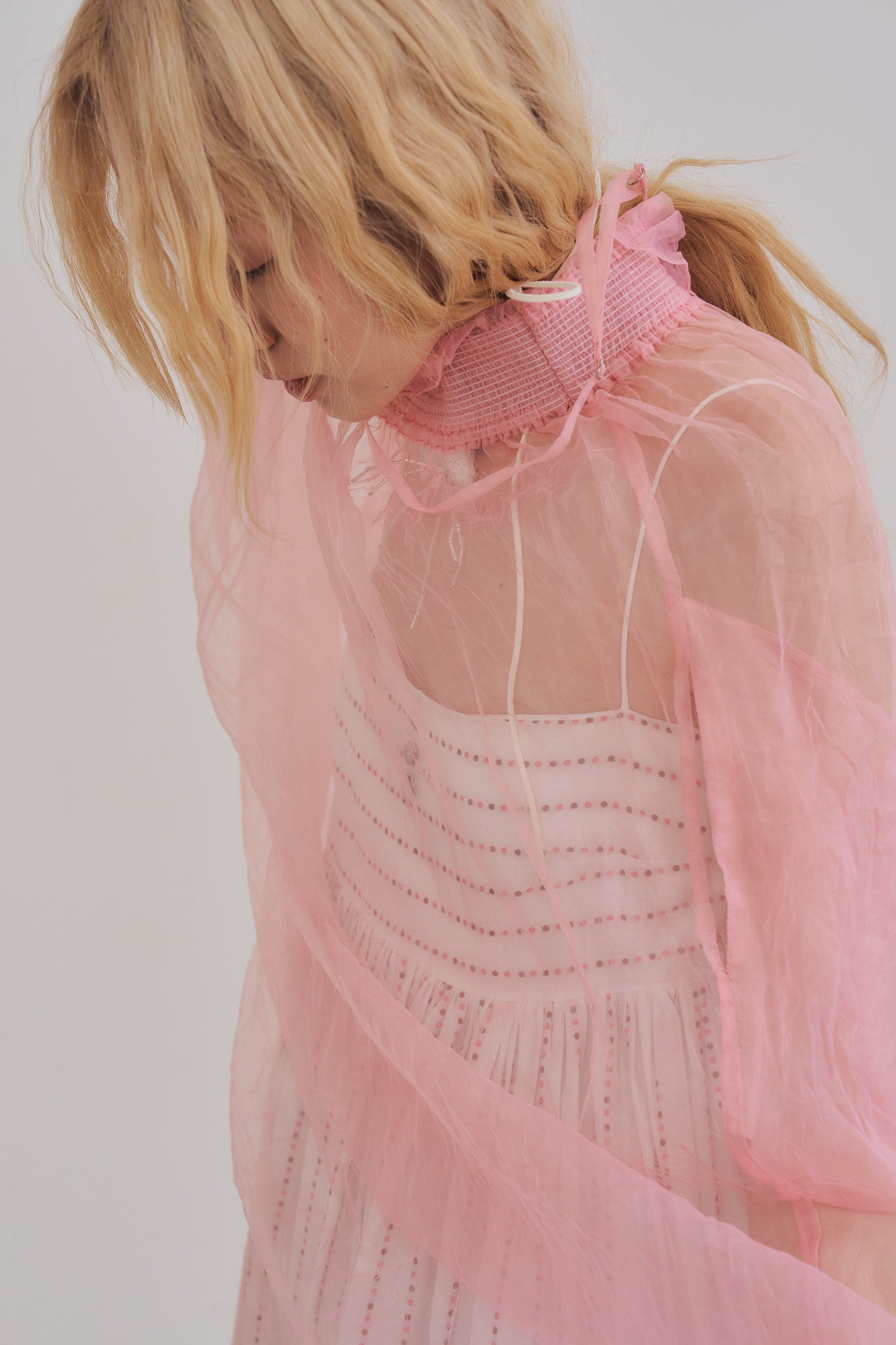 模特兒正面穿著櫻花粉透感歐干紗長洋裝，內搭白色花紋洋裝，展現手工縫製層次與輕盈飄逸感。