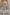 模特兒穿著三層雙拉鏈蕾絲洋裝「卡其格紋」，卡其色格紋布與日本蕾絲層層拼接，搭配前胸雙拉鍊與兩側口袋設計，呈現溫潤又俐落的廓形。