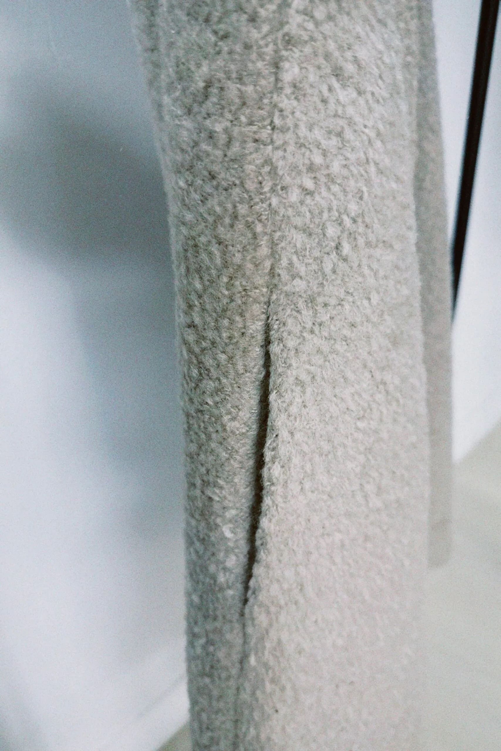 朦朧灰羊絨背心洋裝外套近照，柔軟羊絨面料搭配立體花釦、後開衩與側袋設計，展現優雅多變造型。