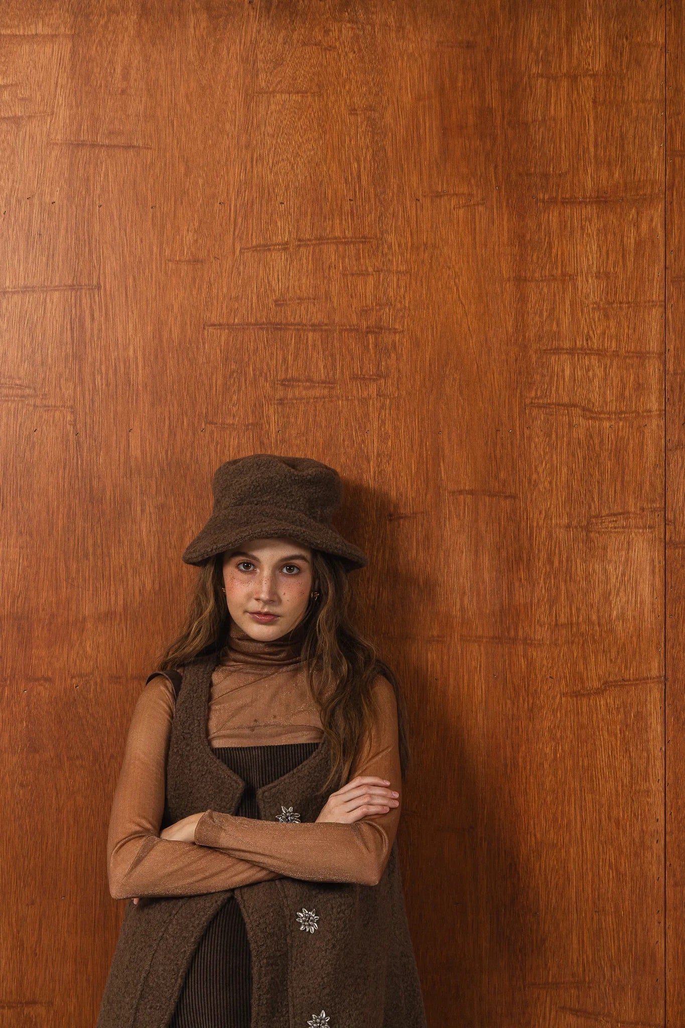 模特兒配戴手作白色羊絨鐘形帽，喀什米爾面料與硬挺帽緣，呈現溫潤質感與修飾臉型的秋冬造型。