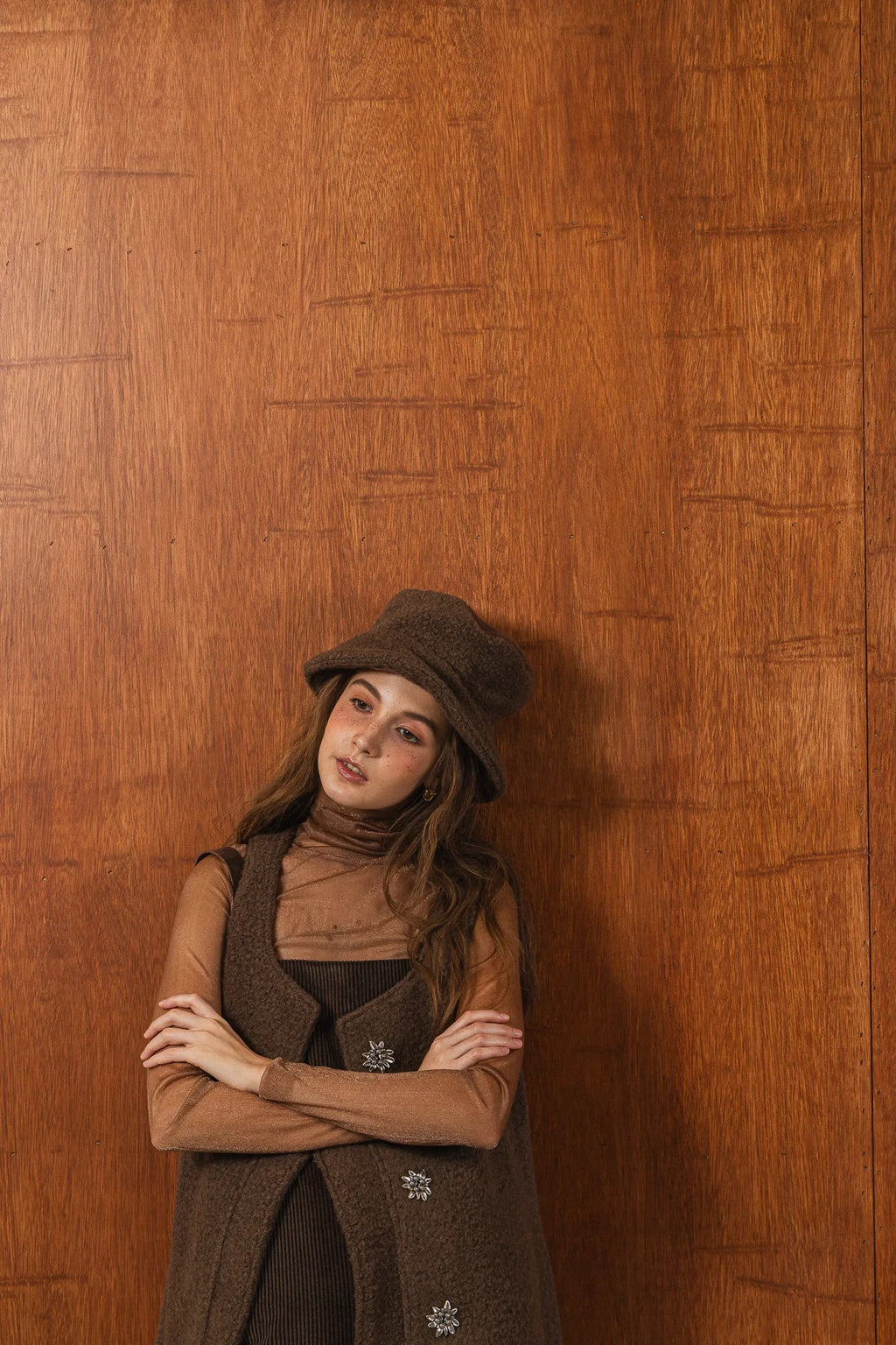 模特兒配戴手作白色羊絨鐘形帽，喀什米爾面料與硬挺帽緣，呈現溫潤質感與修飾臉型的秋冬造型。