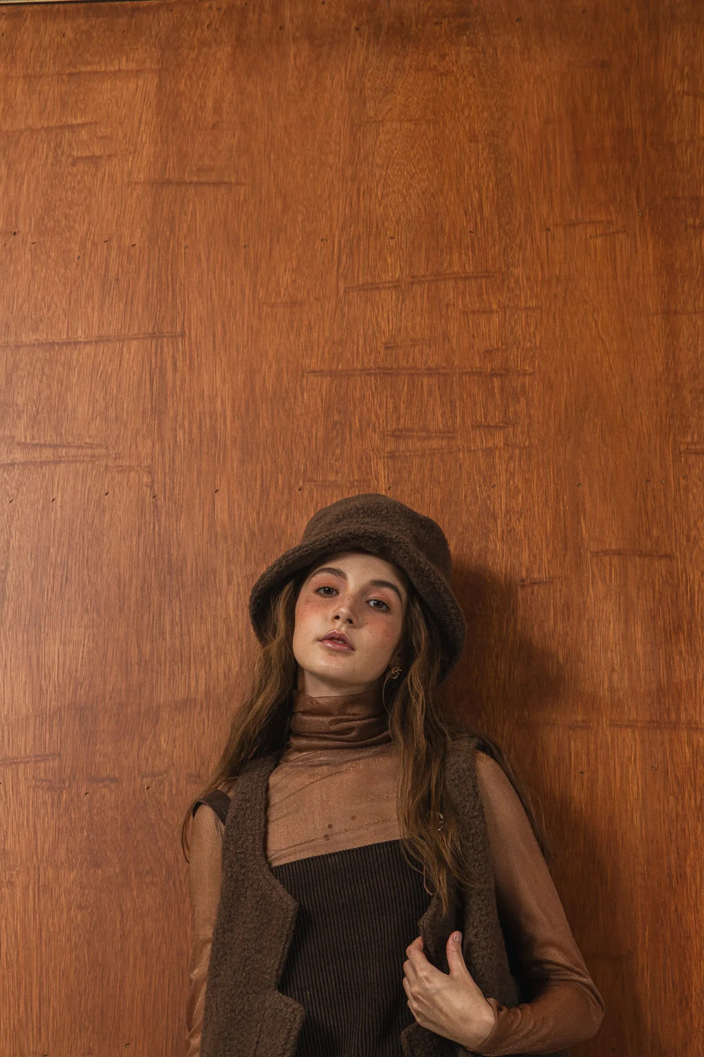 模特兒配戴手作白色羊絨鐘形帽，喀什米爾面料與硬挺帽緣，呈現溫潤質感與修飾臉型的秋冬造型。