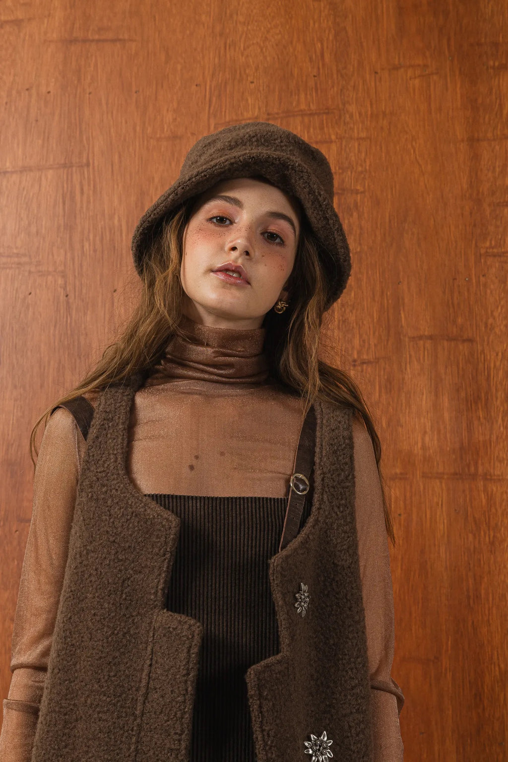 模特兒配戴手作白色羊絨鐘形帽，喀什米爾面料與硬挺帽緣，呈現溫潤質感與修飾臉型的秋冬造型。