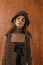 模特兒配戴手作白色羊絨鐘形帽，喀什米爾面料與硬挺帽緣，呈現溫潤質感與修飾臉型的秋冬造型。