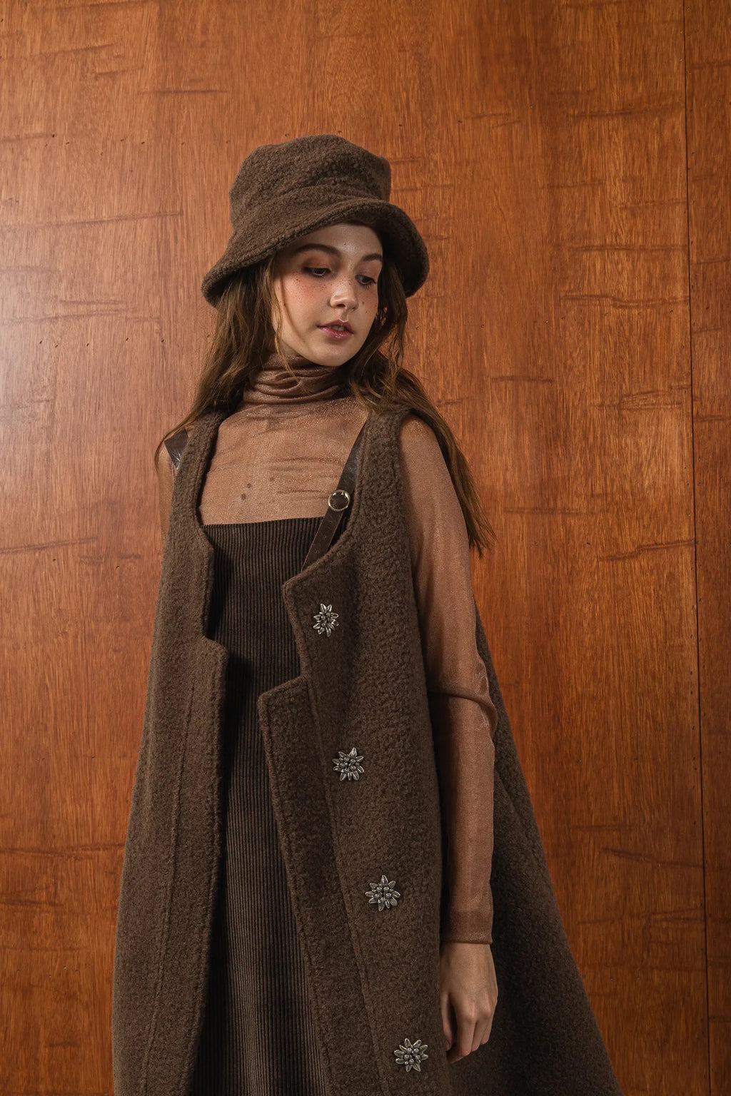 模特兒配戴手作白色羊絨鐘形帽，喀什米爾面料與硬挺帽緣，呈現溫潤質感與修飾臉型的秋冬造型。