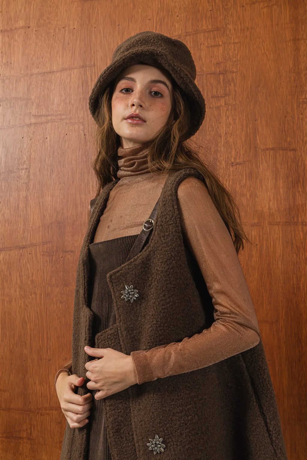 模特兒配戴手作白色羊絨鐘形帽，喀什米爾面料與硬挺帽緣，呈現溫潤質感與修飾臉型的秋冬造型。