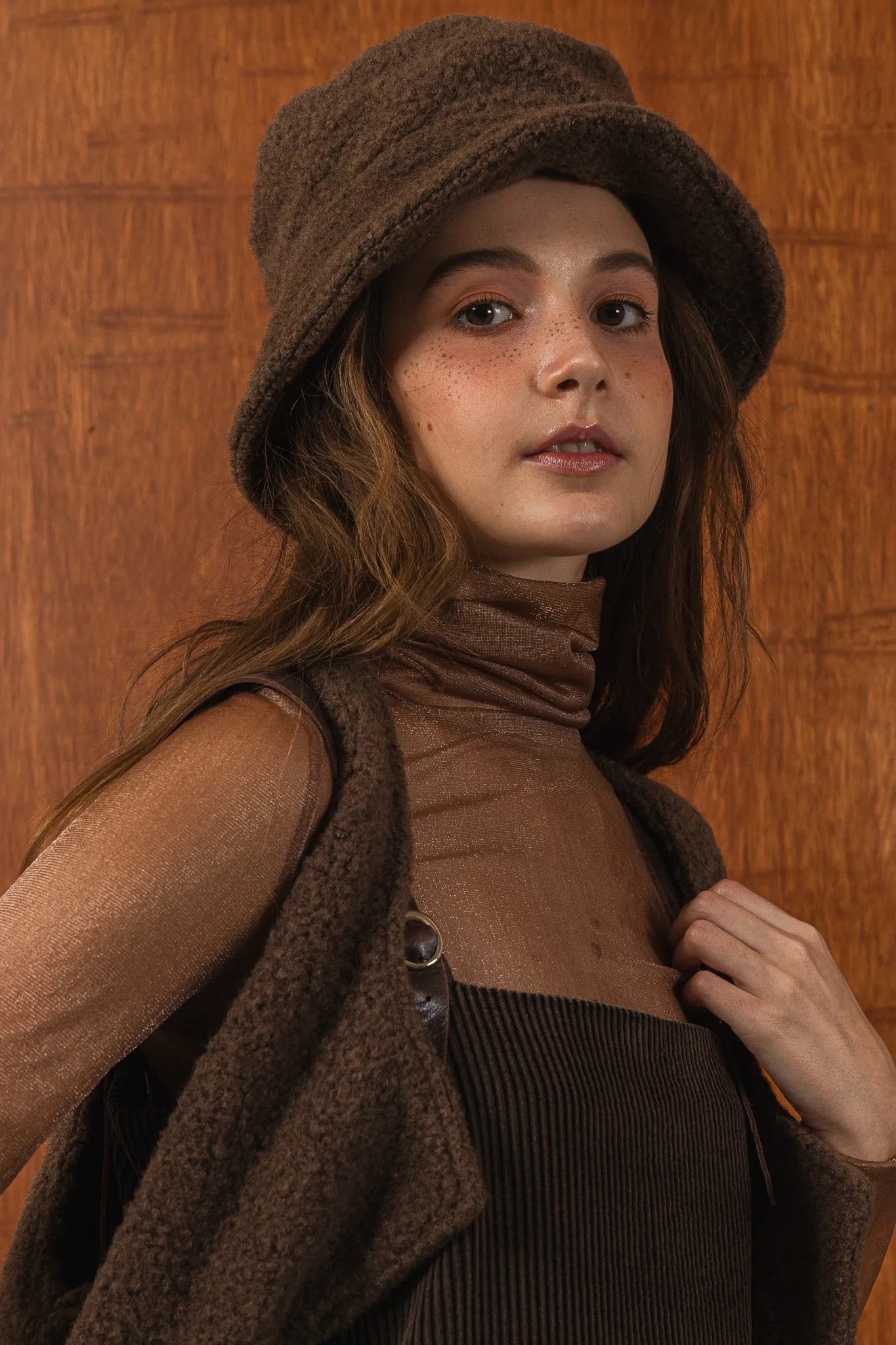 模特兒配戴手作白色羊絨鐘形帽，喀什米爾面料與硬挺帽緣，呈現溫潤質感與修飾臉型的秋冬造型。