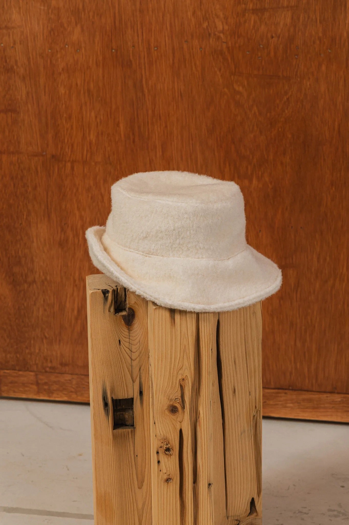 手作白色羊絨鐘形帽近照，喀什米爾面料與硬挺帽緣，呈現溫潤質感秋冬氛圍。