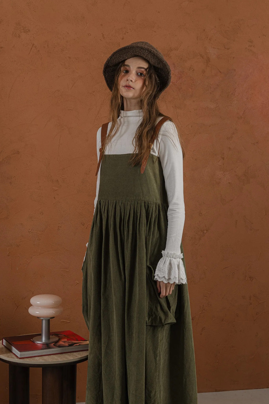 軍綠絨面口袋洋裝，日本純棉立體口袋與小羊皮肩帶高腰抽皺，展現優雅率性輪廓。