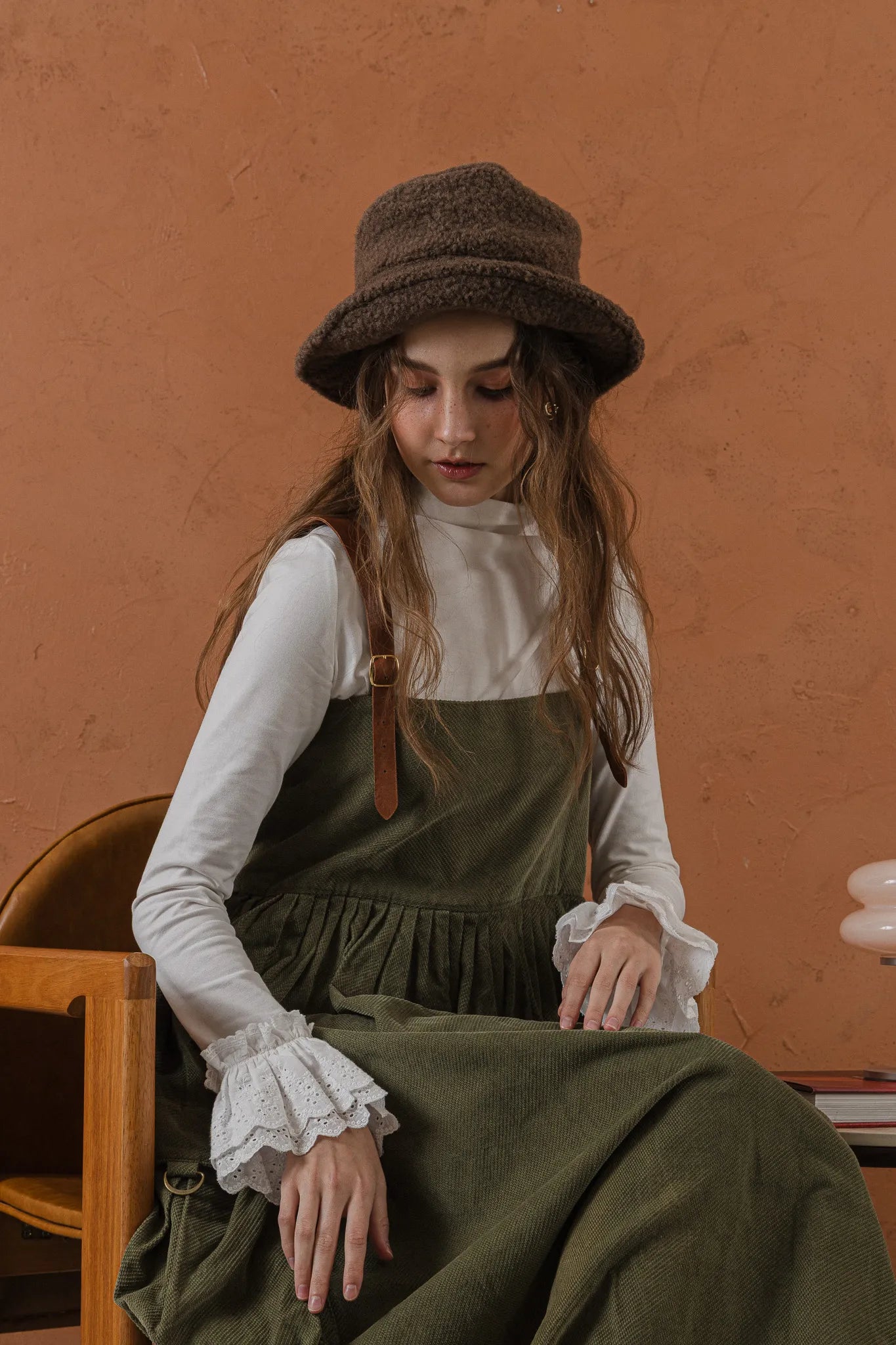 模特兒穿著清晨白蕾絲裝飾袖上衣，毛感面料質地柔軟舒適，袖口蕾絲細節為日常造型增添優雅儀式感。