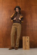 模特兒穿著拼接上衣披肩款，衣服為橘色與棕色拼接、多層次造型，呈現溫暖且有設計感的穿搭風格。