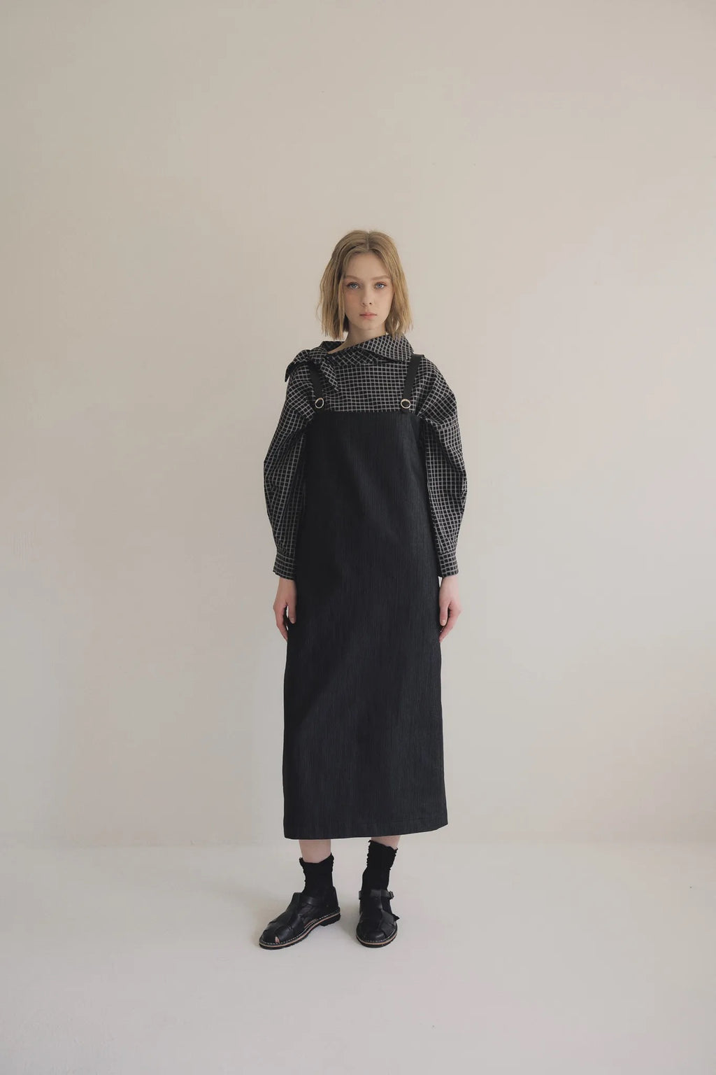 模特兒穿著光澤牛仔細肩帶洋裝，日本光澤牛仔面料搭配小牛皮細肩帶，後開衩與 H Line 剪裁，展現優雅又率性的造型。