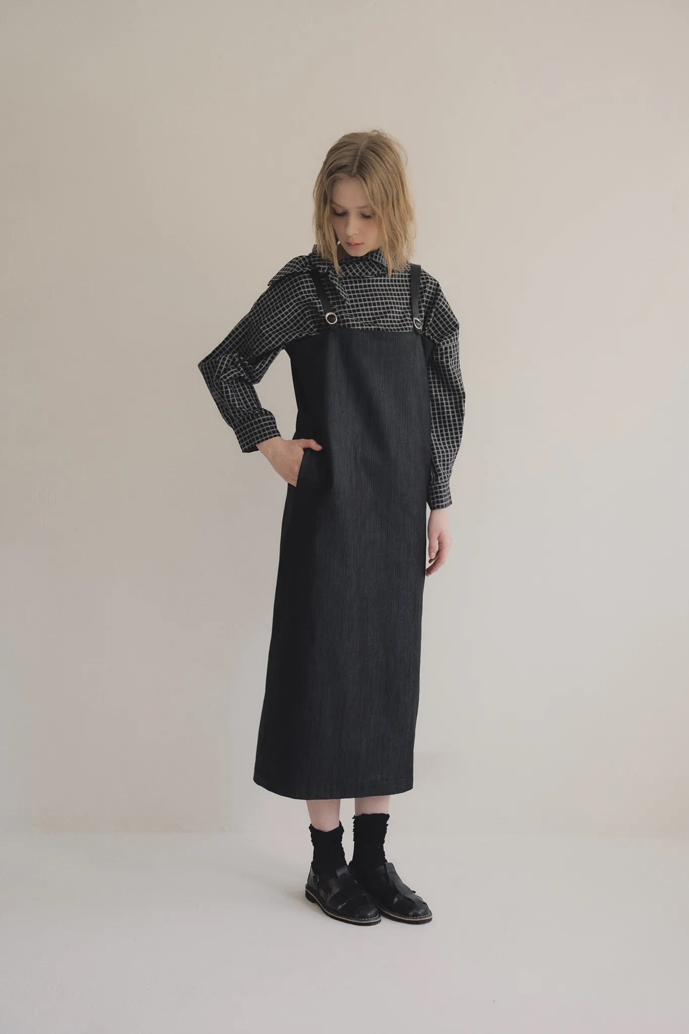 模特兒穿著光澤牛仔細肩帶洋裝，日本光澤牛仔面料搭配小牛皮細肩帶，後開衩與 H Line 剪裁，展現優雅又率性的造型。