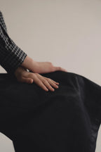 模特兒穿著光澤牛仔細肩帶洋裝，日本光澤牛仔面料搭配小牛皮細肩帶，後開衩與 H Line 剪裁，展現優雅又率性的造型。