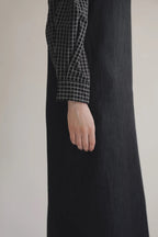 模特兒穿著光澤牛仔細肩帶洋裝，日本光澤牛仔面料搭配小牛皮細肩帶，後開衩與 H Line 剪裁，展現優雅又率性的造型。