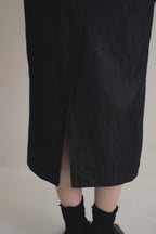 模特兒穿著光澤牛仔細肩帶洋裝，日本光澤牛仔面料搭配小牛皮細肩帶，後開衩與 H Line 剪裁，展現優雅又率性的造型。