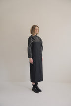 模特兒穿著光澤牛仔細肩帶洋裝，日本光澤牛仔面料搭配小牛皮細肩帶，後開衩與 H Line 剪裁，展現優雅又率性的造型。