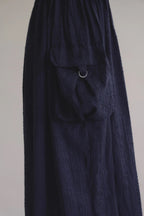 深藍肩帶雙口袋廓形洋裝，口袋細節。