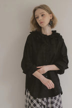 模特兒穿著黑色罌粟領設計襯衫，日本純棉親膚透氣，花瓣領口展現優雅叛逆的詩意造型。