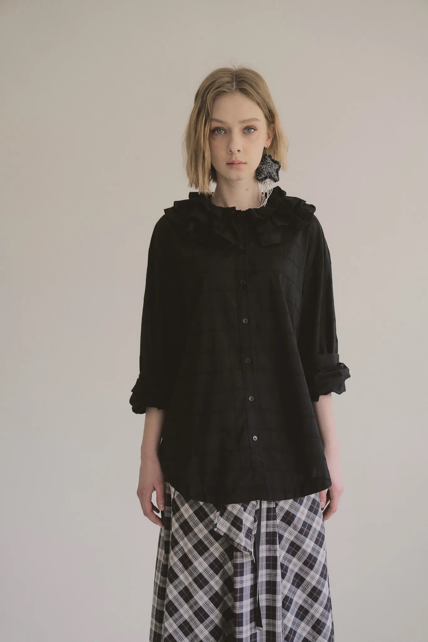 模特兒穿著黑色罌粟領設計襯衫，日本純棉親膚透氣，花瓣領口展現優雅叛逆的詩意造型。