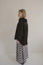 模特兒穿著黑色罌粟領設計襯衫，日本純棉親膚透氣，花瓣領口展現優雅叛逆的詩意造型。