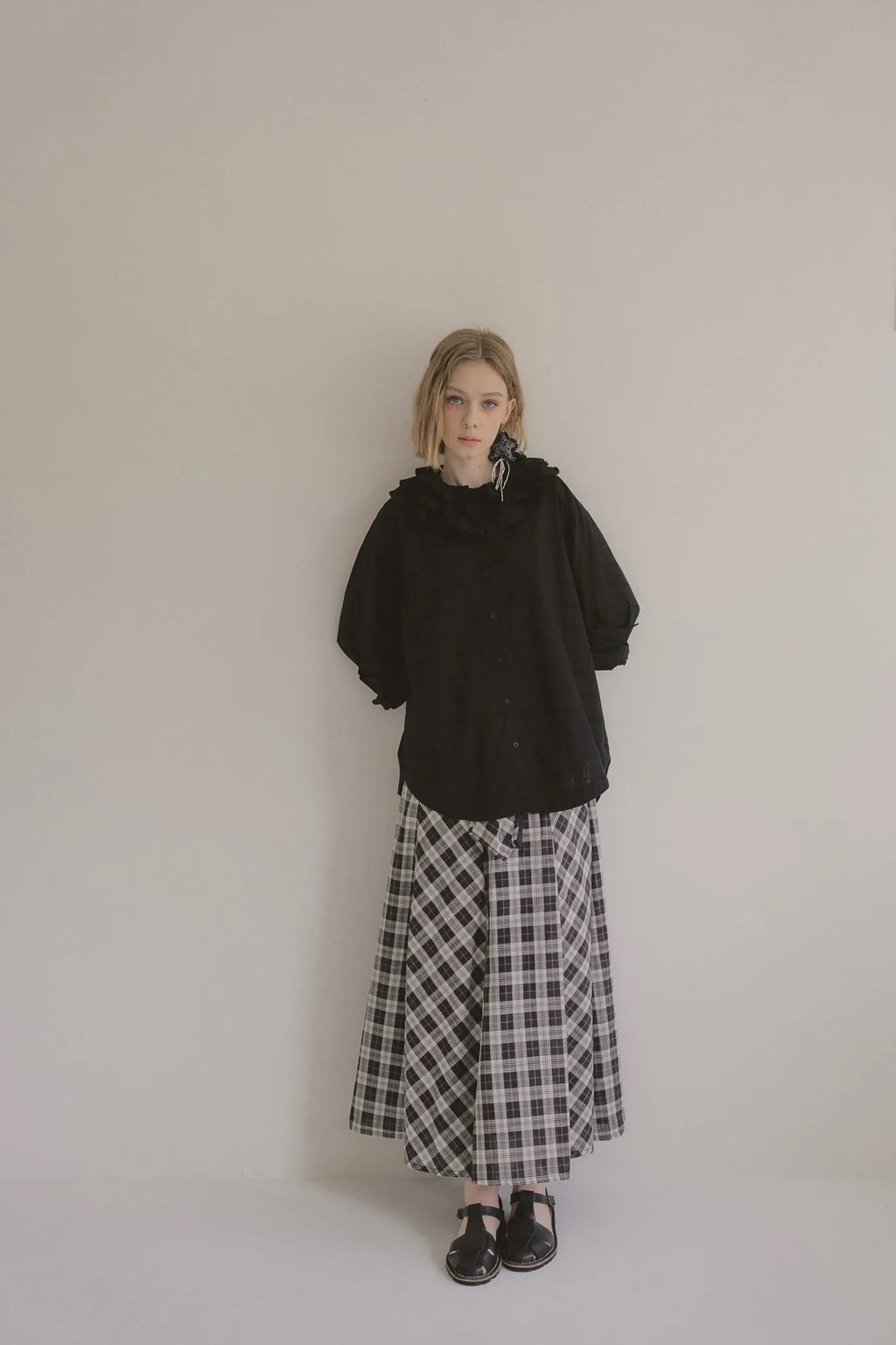 模特兒穿著黑色罌粟領設計襯衫，日本純棉親膚透氣，花瓣領口展現優雅叛逆的詩意造型。