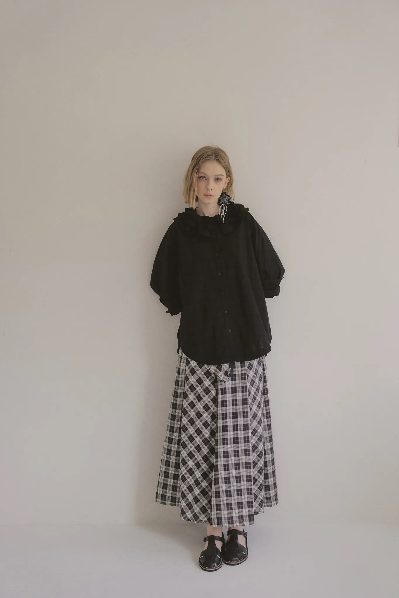 模特兒穿著黑色罌粟領設計襯衫，日本純棉親膚透氣，花瓣領口展現優雅叛逆的詩意造型。