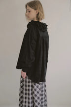 模特兒穿著黑色罌粟領設計襯衫，日本純棉親膚透氣，花瓣領口展現優雅叛逆的詩意造型。