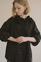 模特兒穿著黑色罌粟領設計襯衫，日本純棉親膚透氣，花瓣領口展現優雅叛逆的詩意造型。