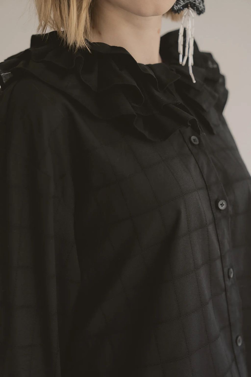 模特兒穿著黑色罌粟領設計襯衫，日本純棉親膚透氣，花瓣領口展現優雅叛逆的詩意造型。