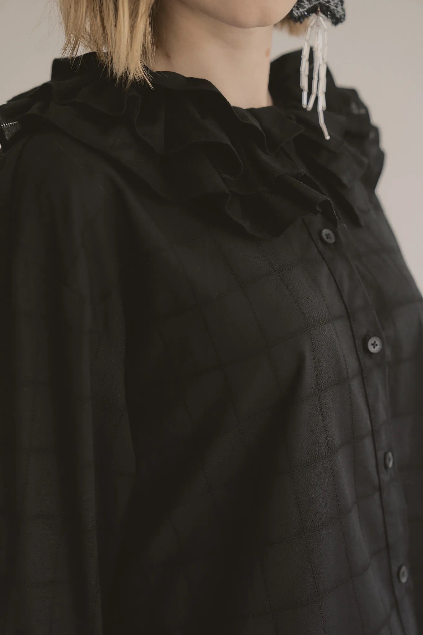 模特兒穿著黑色罌粟領設計襯衫，日本純棉親膚透氣，花瓣領口展現優雅叛逆的詩意造型。