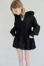 模特兒穿著黑色罌粟領設計襯衫，日本純棉親膚透氣，花瓣領口展現優雅叛逆的詩意造型。