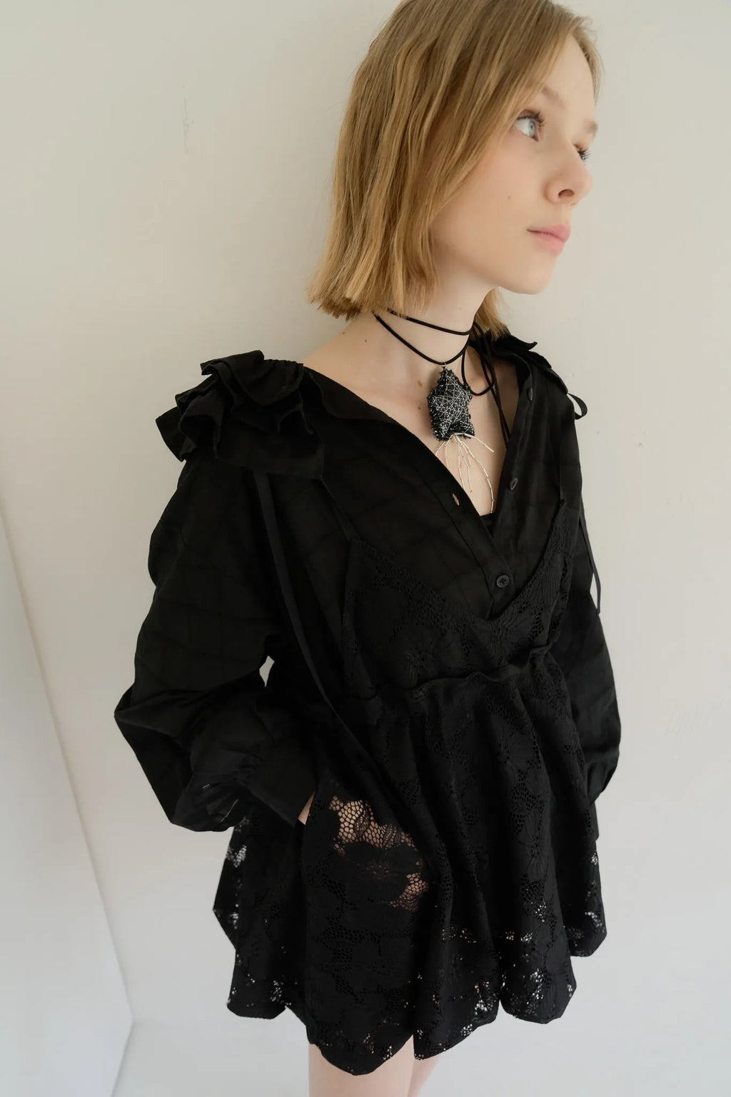 模特兒穿著黑色罌粟領設計襯衫，日本純棉親膚透氣，花瓣領口展現優雅叛逆的詩意造型。