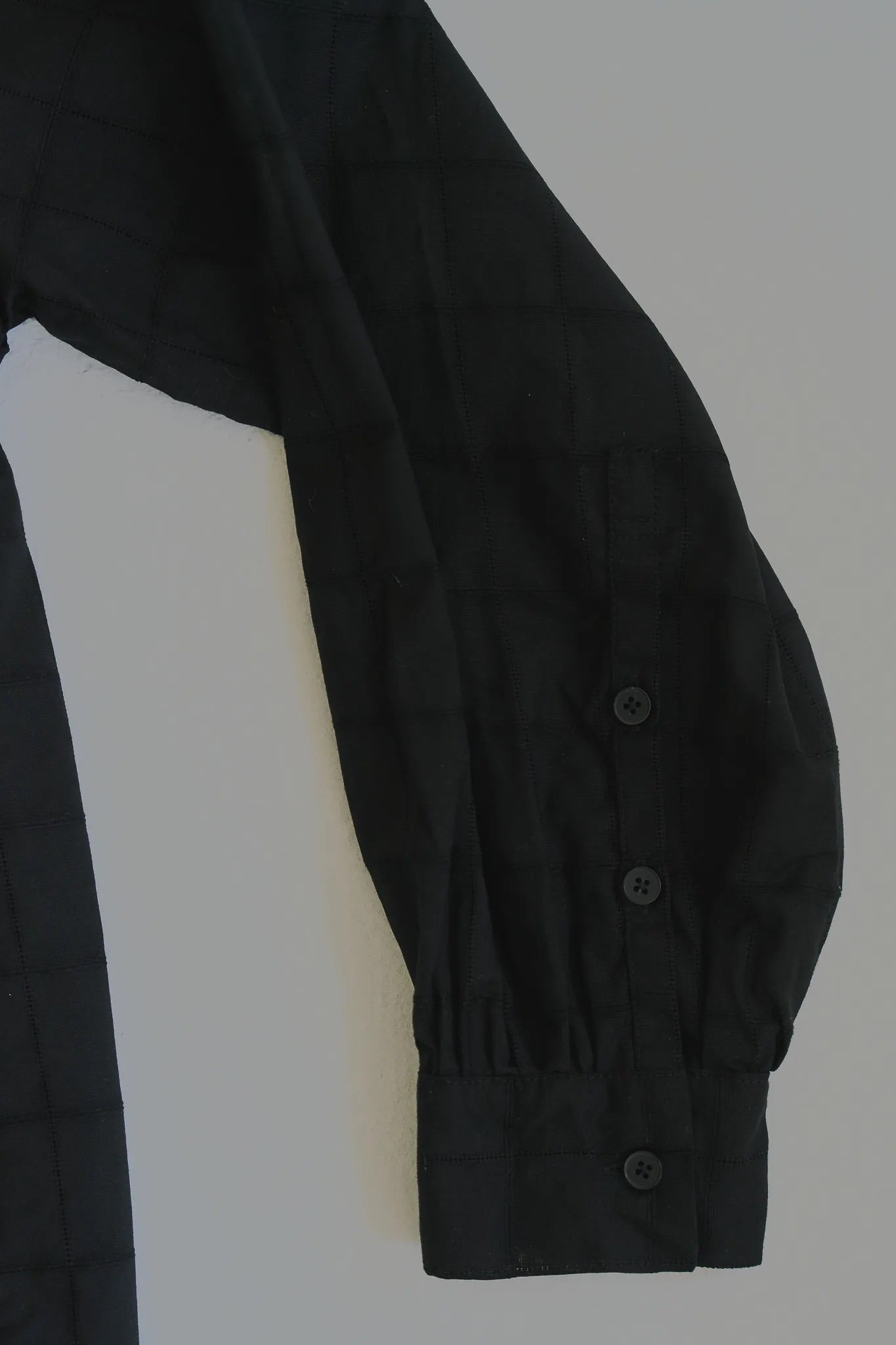 模特兒穿著黑色罌粟領設計襯衫，日本純棉親膚透氣，花瓣領口展現優雅叛逆的詩意造型。