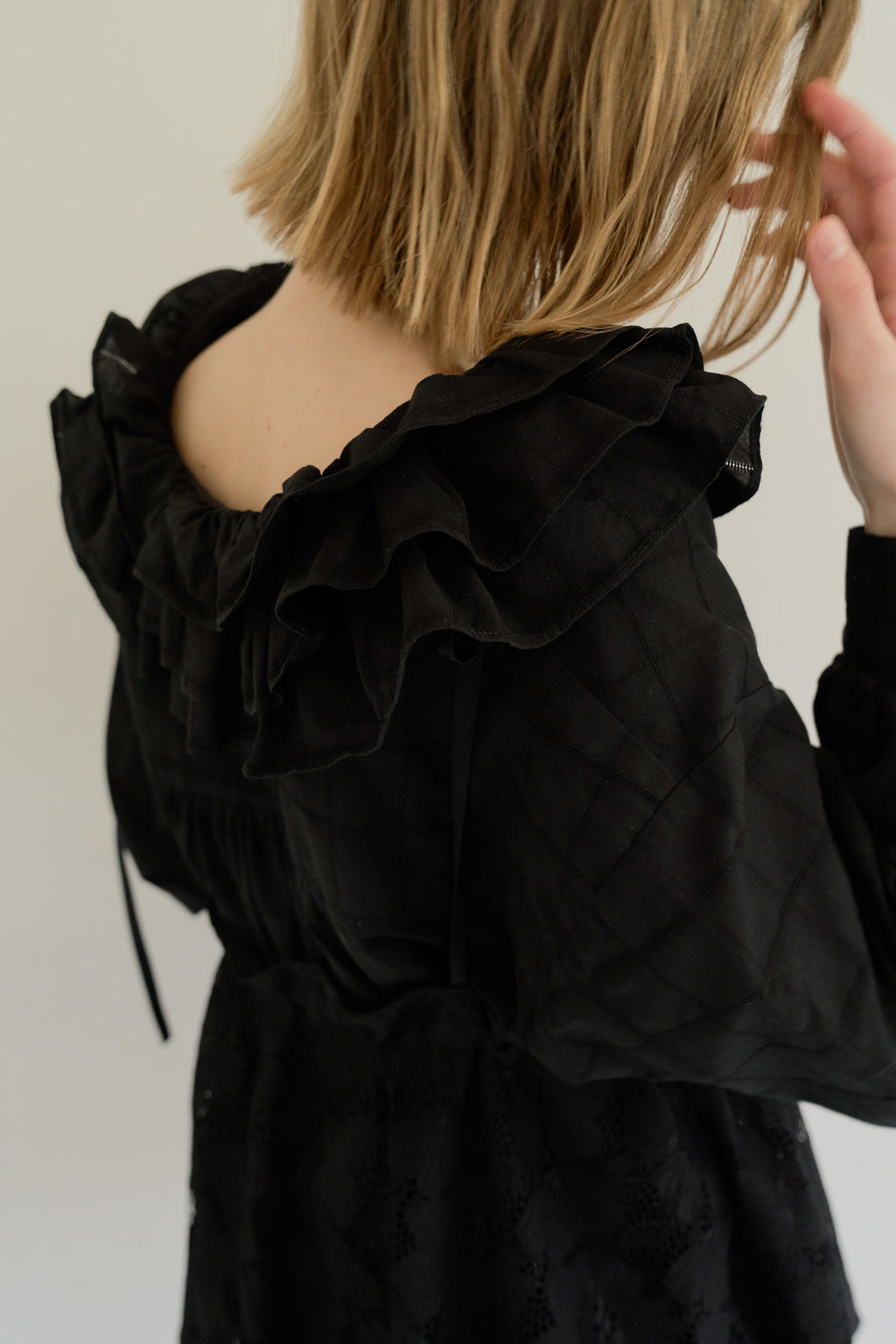 模特兒穿著黑色罌粟領設計襯衫，日本純棉親膚透氣，花瓣領口展現優雅叛逆的詩意造型。