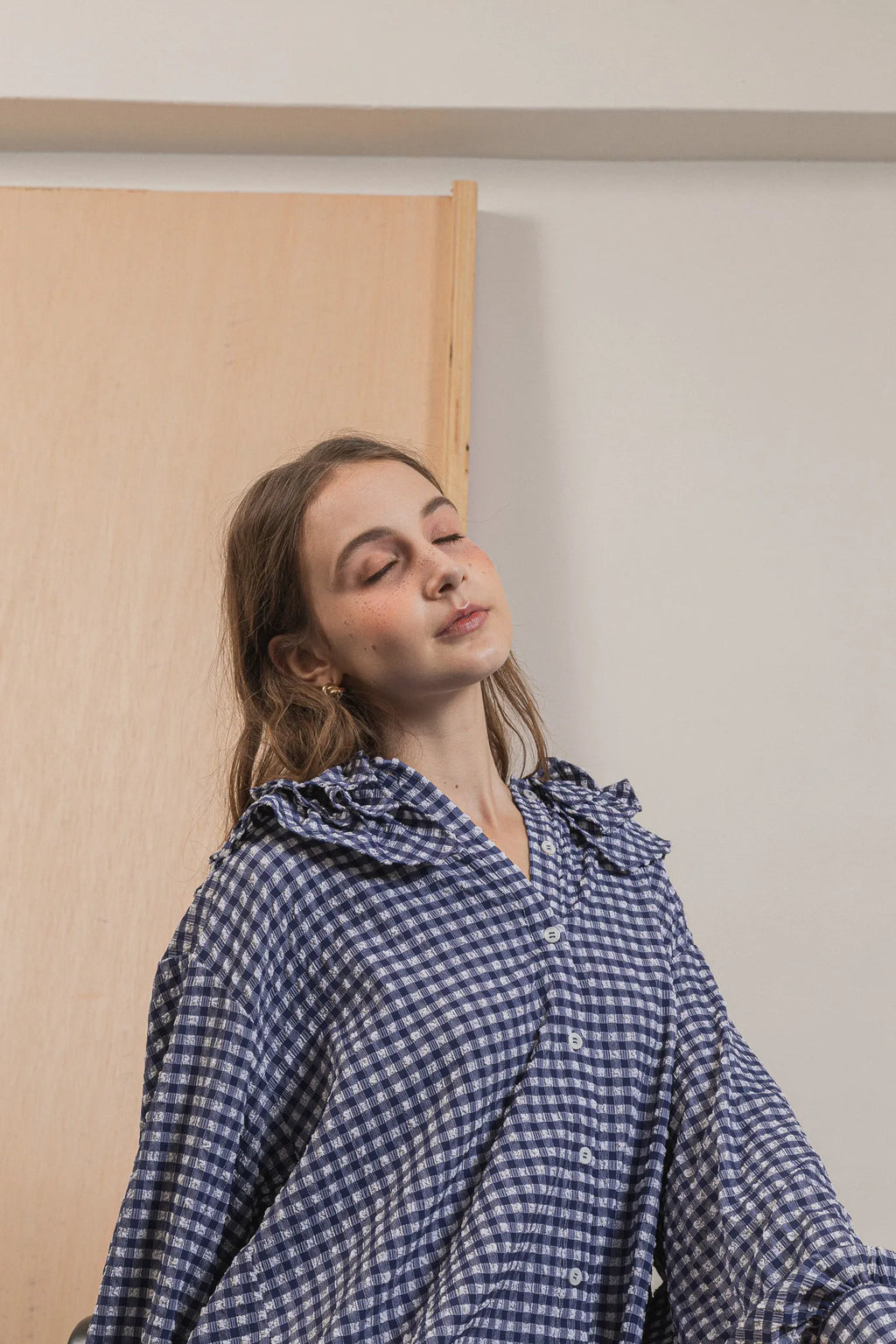 模特兒穿著天空格紋罌粟領襯衫，獨特觸感面料與花瓣領設計展現優雅叛逆的輕鬆浪漫造型。