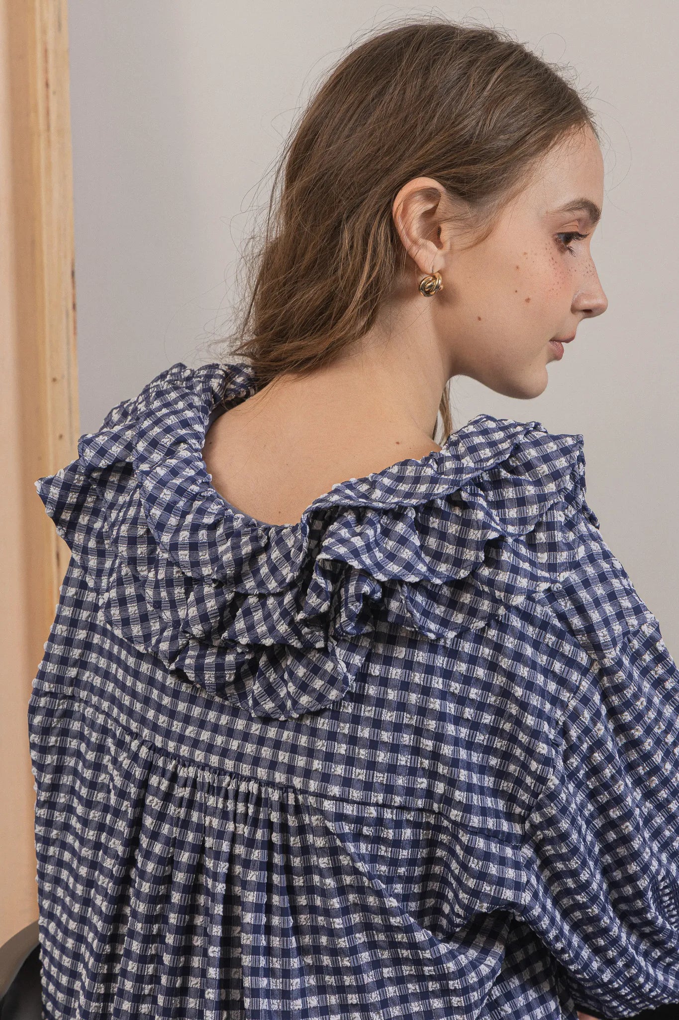 模特兒穿著天空格紋罌粟領襯衫，獨特觸感面料與花瓣領設計展現優雅叛逆的輕鬆浪漫造型。