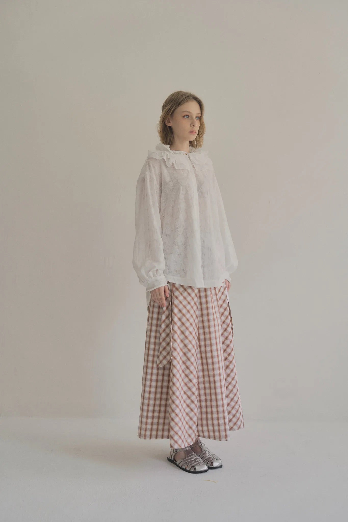 模特兒穿著白色罌粟領設計襯衫，日本純棉親膚透氣，花瓣領口展現優雅叛逆的詩意造型。