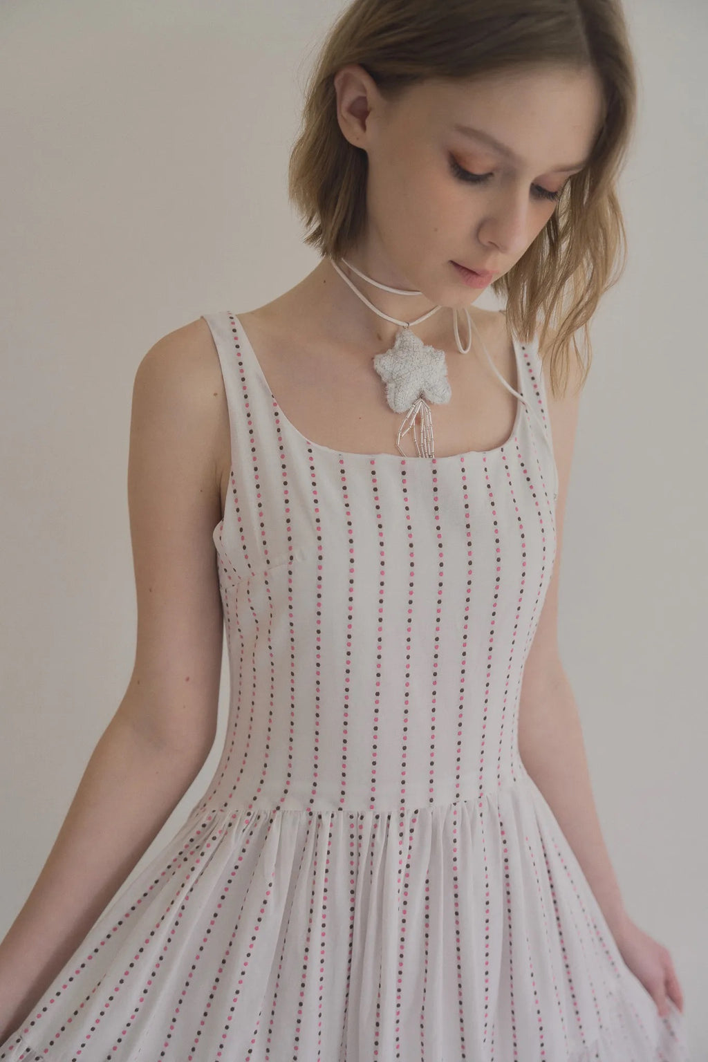 無袖粉色水玉棉洋裝，箱褶裙擺不透膚側拉鍊甜美層次。