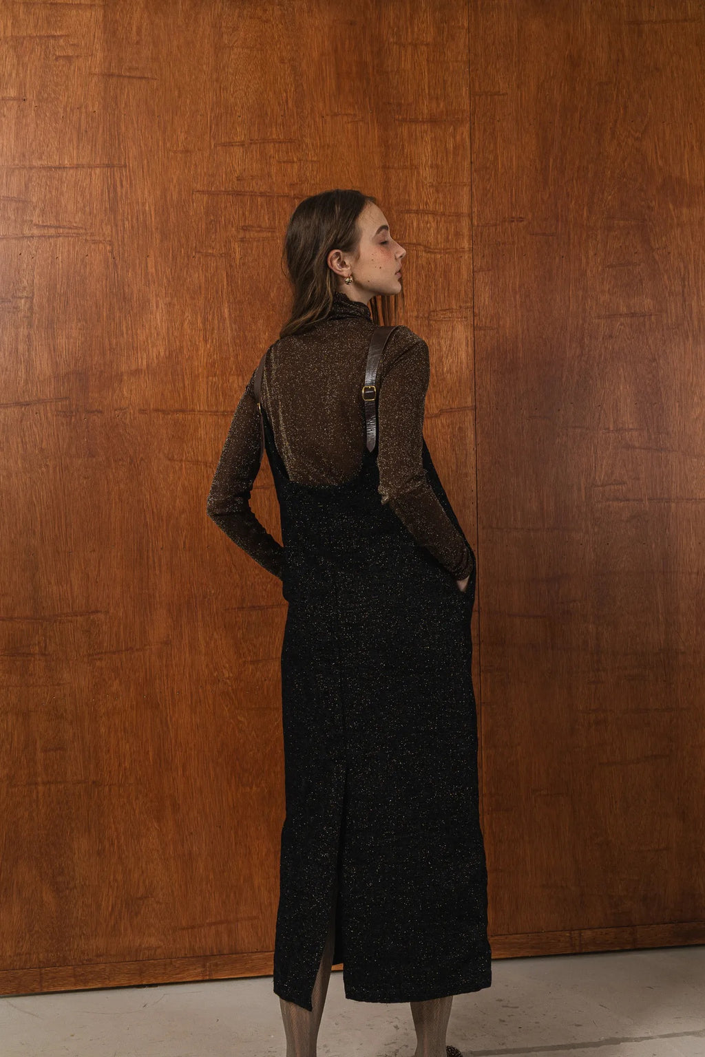 模特兒穿著羊毛花紗細肩帶洋裝，日本金蔥羊毛面料閃耀細膩質感，側口袋、後開衩與羊皮肩帶展現率性優雅 H Line 造型。