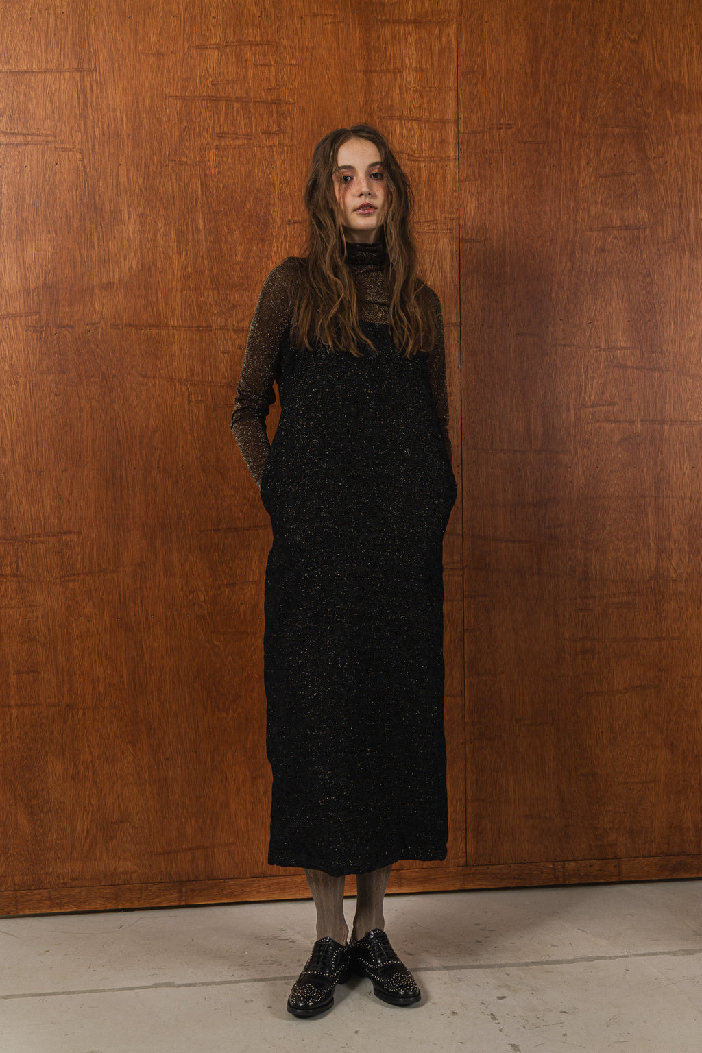 模特兒穿著羊毛花紗細肩帶洋裝，日本金蔥羊毛面料閃耀細膩質感，側口袋、後開衩與羊皮肩帶展現率性優雅 H Line 造型。