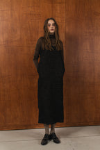 模特兒穿著羊毛花紗細肩帶洋裝，日本金蔥羊毛面料閃耀細膩質感，側口袋、後開衩與羊皮肩帶展現率性優雅 H Line 造型。