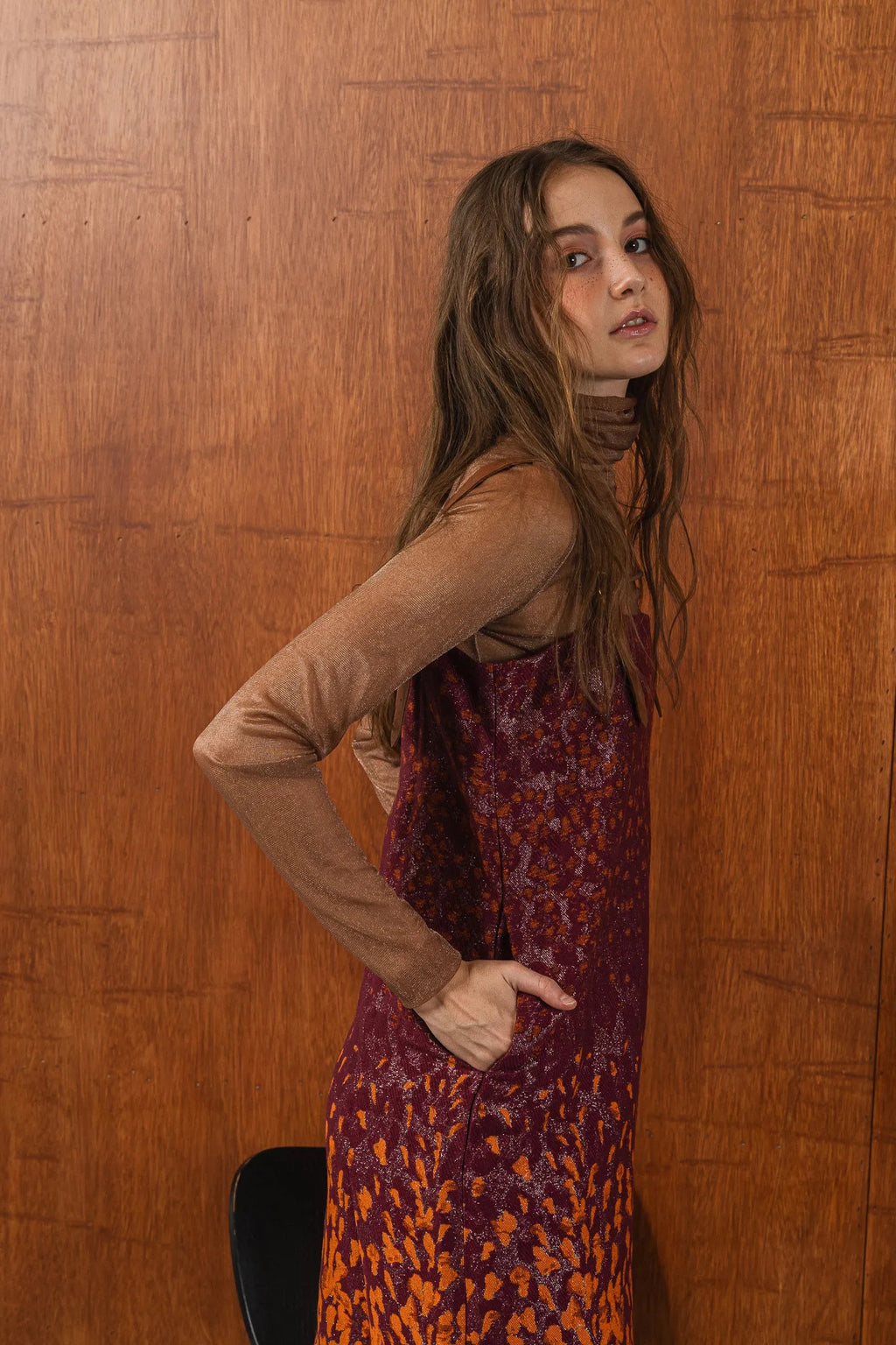 模特兒穿著羊毛花紗細肩帶洋裝，日本金蔥羊毛面料閃耀細膩質感，側口袋、後開衩與羊皮肩帶展現率性優雅 H Line 造型。