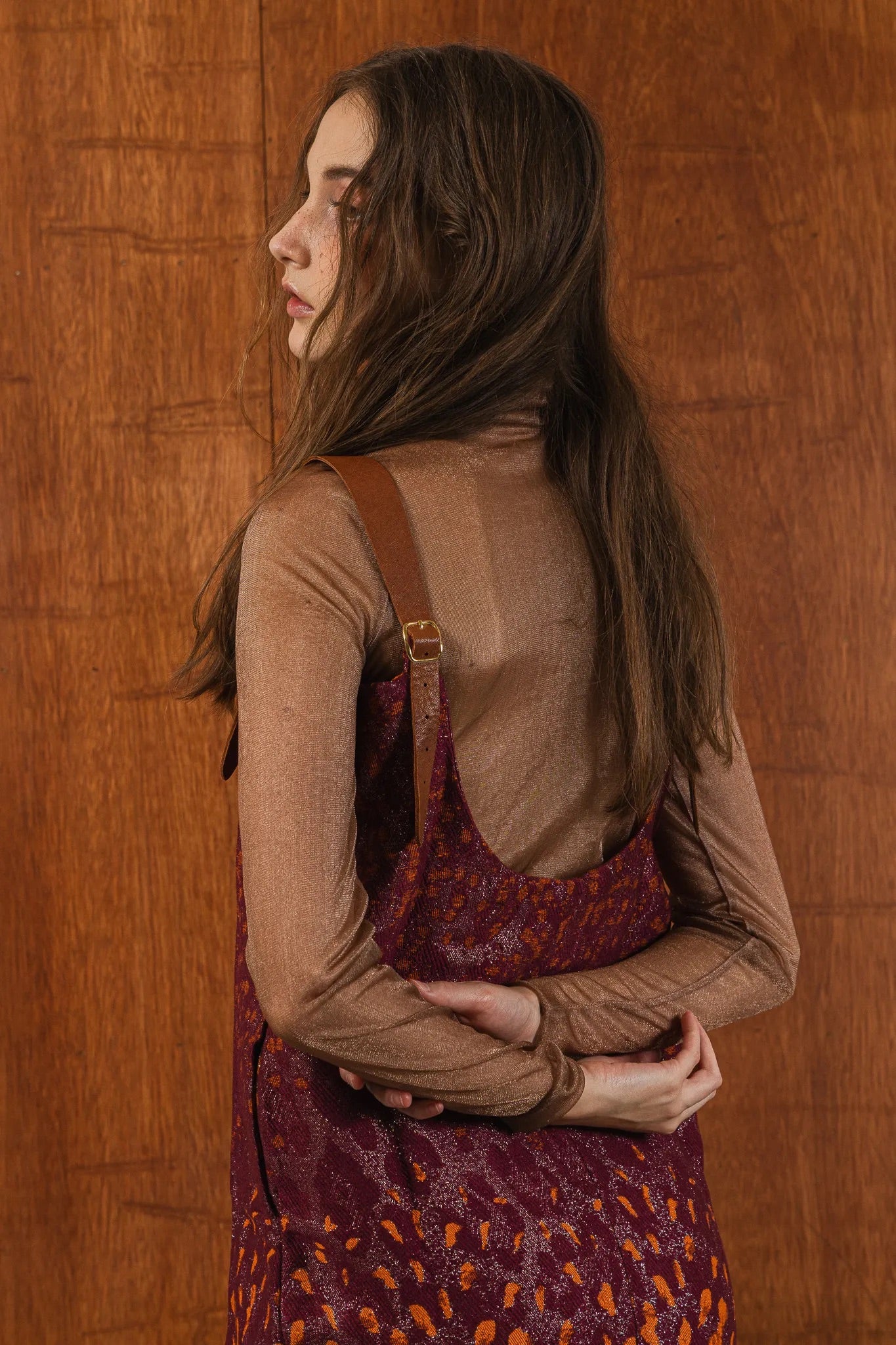 模特兒穿著羊毛花紗細肩帶洋裝，日本金蔥羊毛面料閃耀細膩質感，側口袋、後開衩與羊皮肩帶展現率性優雅 H Line 造型。