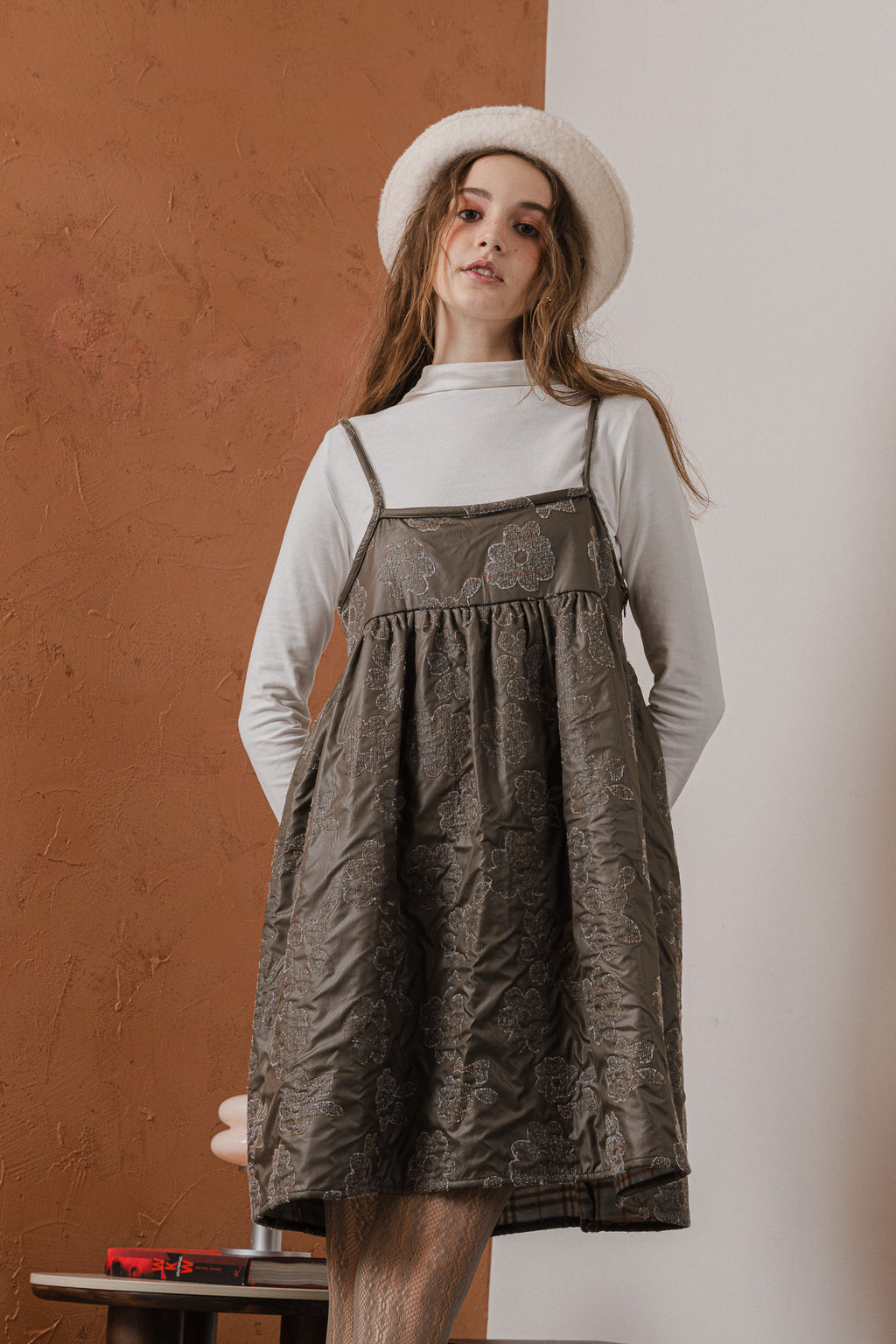 模特兒穿著羊毛花瓣細肩帶洋裝，特殊羊毛花布面料風衣質感，內裡鋪棉設計展現舒適實用的日常造型。