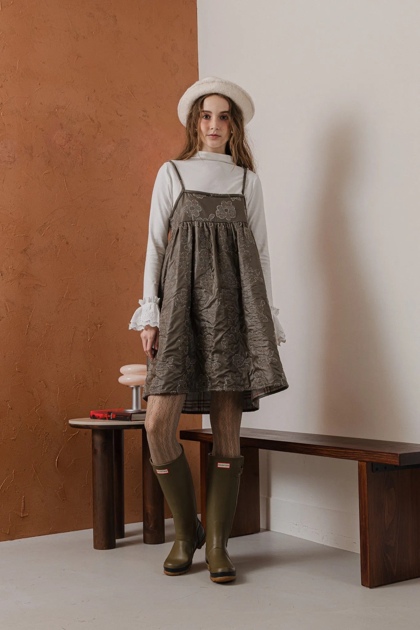 模特兒穿著羊毛花瓣細肩帶洋裝，特殊羊毛花布面料風衣質感，內裡鋪棉設計展現舒適實用的日常造型。