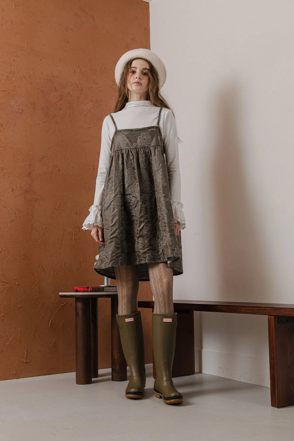 模特兒穿著羊毛花瓣細肩帶洋裝，特殊羊毛花布面料風衣質感，內裡鋪棉設計展現舒適實用的日常造型。