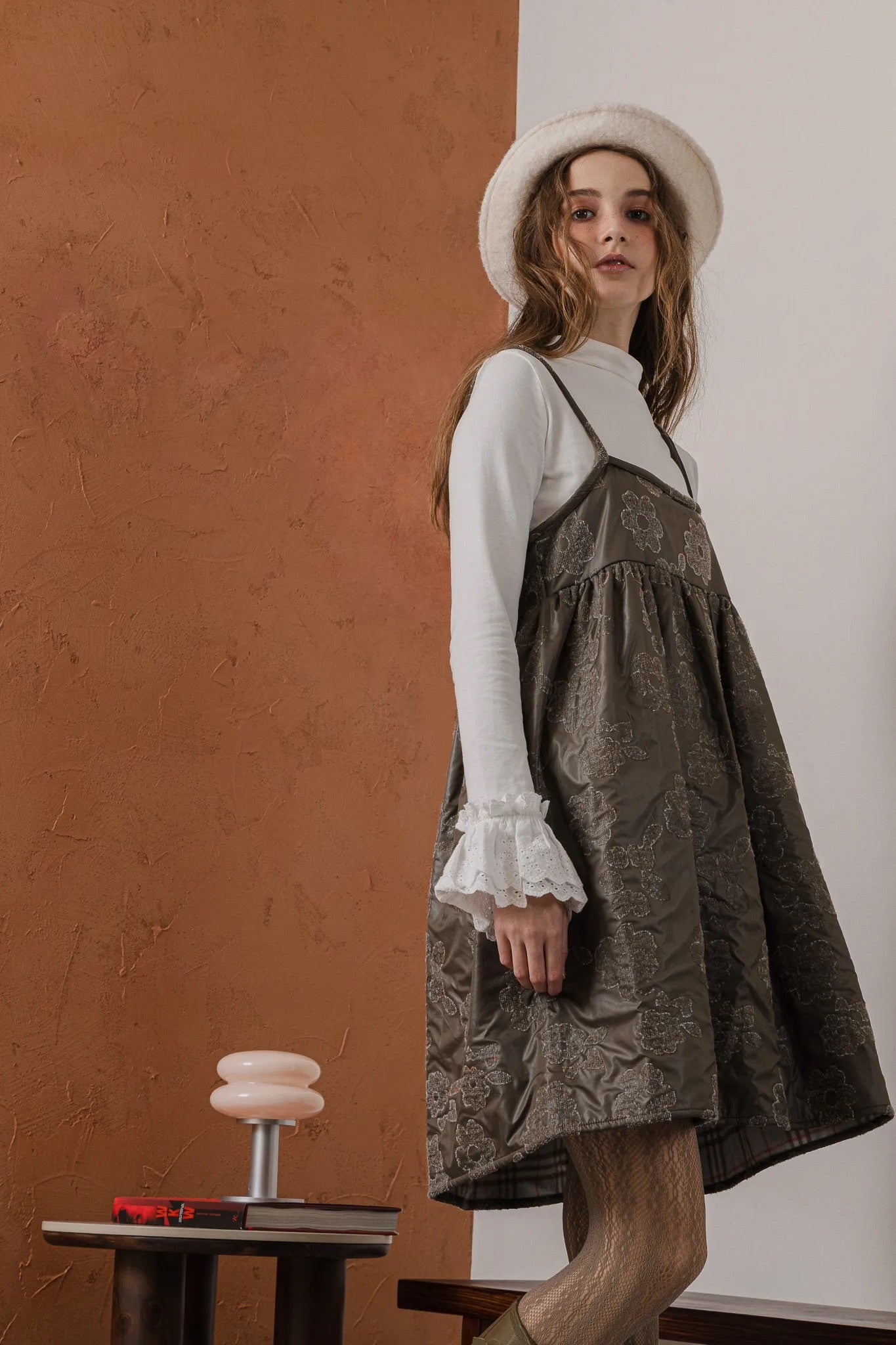 模特兒穿著羊毛花瓣細肩帶洋裝，特殊羊毛花布面料風衣質感，內裡鋪棉設計展現舒適實用的日常造型。